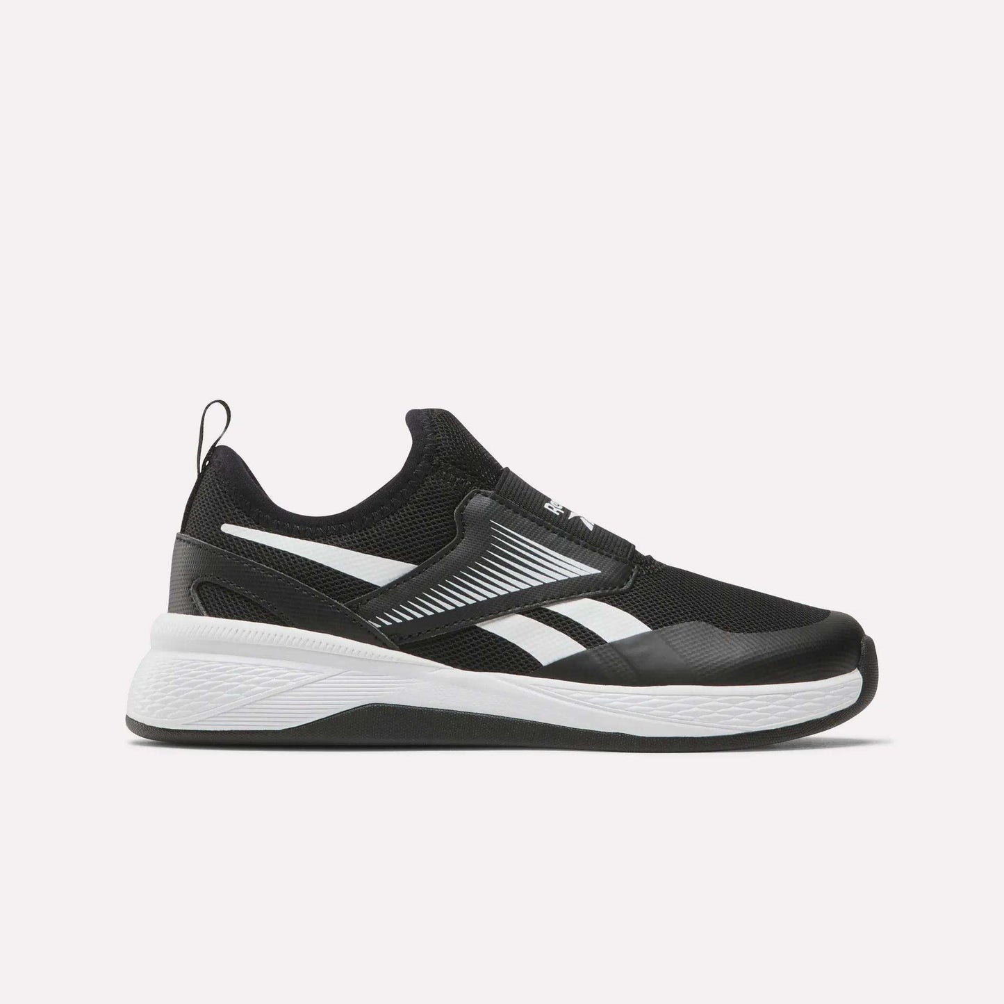 The Reebok Nano Play Slip-On Shoes for little kids have a low-top black mesh upper, white zigzag stripes, and a white sole. Shown from the left side against a plain white background.