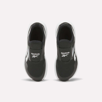 A pair of Reebok Nano Play Slip-On Shoes for little kids in black with white soles, seen from above. The shoes feature the Reebok logo on the tongue and are placed side by side on a plain white background.
