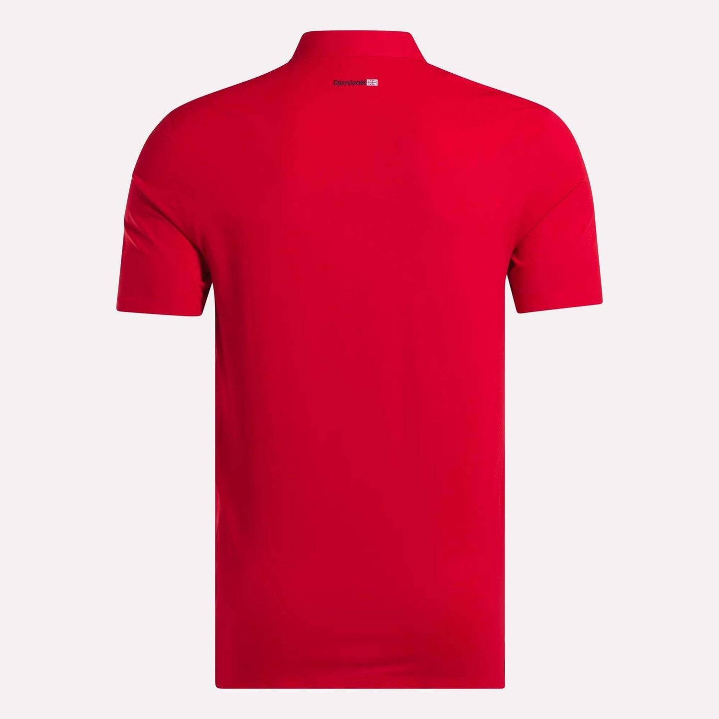 A men's Reebok Short Sleeve Bonded Micro Pique Polo Shirt in plain red is shown from the back, with a small white and red logo by the collar. Made with moisture-wicking fabric, it’s set against a simple light background.