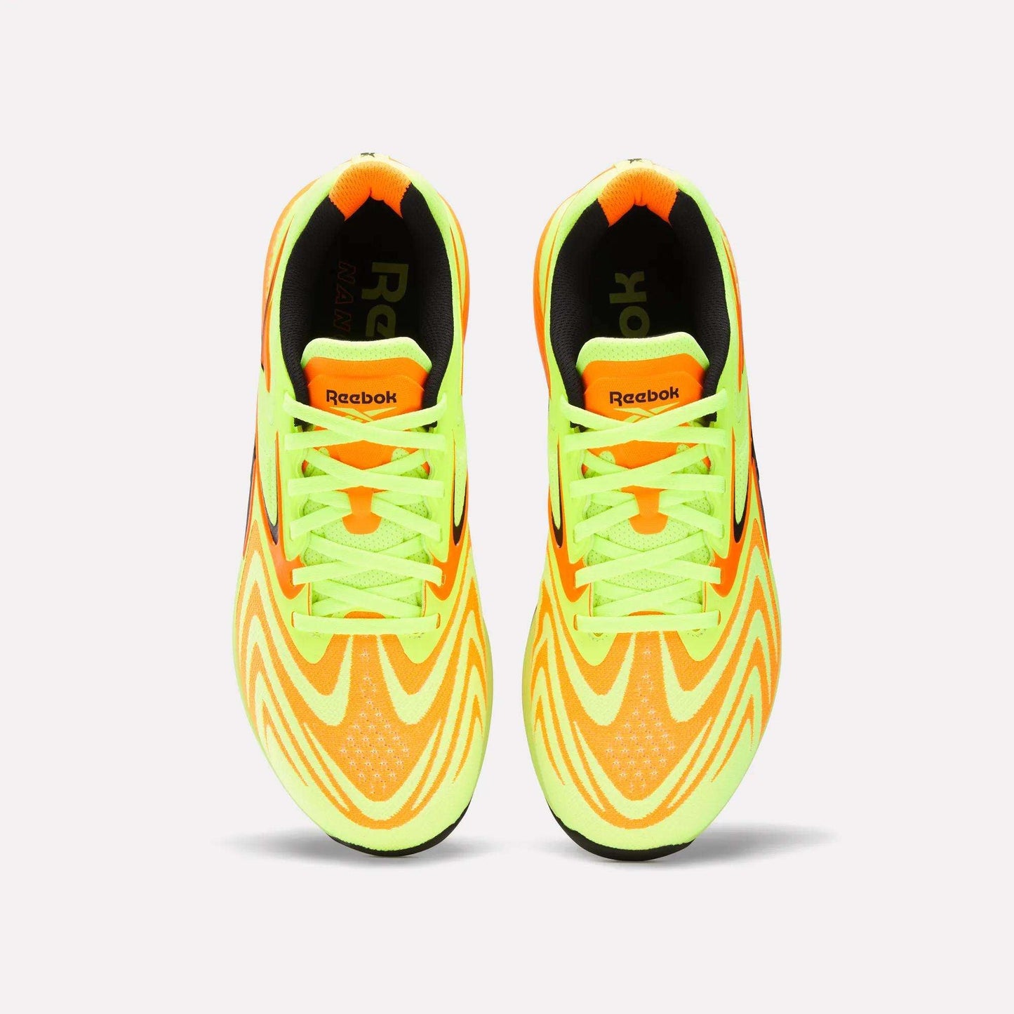 Top view of Reebok Nano X5 Edge Training Shoes with Flexweave material, bright yellow and orange wavy patterns, neon green laces, and black accents on the inner sole and heel.