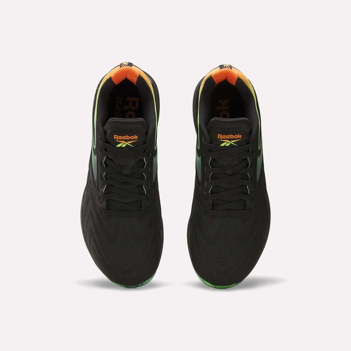 A top view of the Reebok Nano X5 Edge Training Shoes in black, featuring gradient green and orange heel accents, Flexweave support material, and vibrant Reebok logos on the tongue.