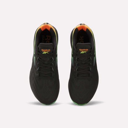 A top view of the Reebok Nano X5 Edge Training Shoes in black, featuring gradient green and orange heel accents, Flexweave support material, and vibrant Reebok logos on the tongue.