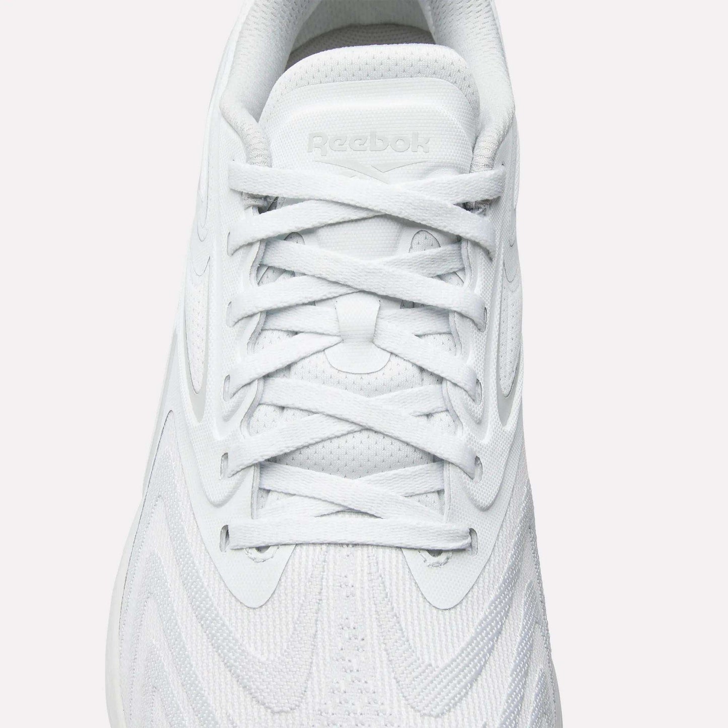 Top view of Reebok Nano X5 Edge Training Shoes in white with white laces, Flexweave textured upper, and embossed Reebok logo on the tongue—precision performance footwear for training.