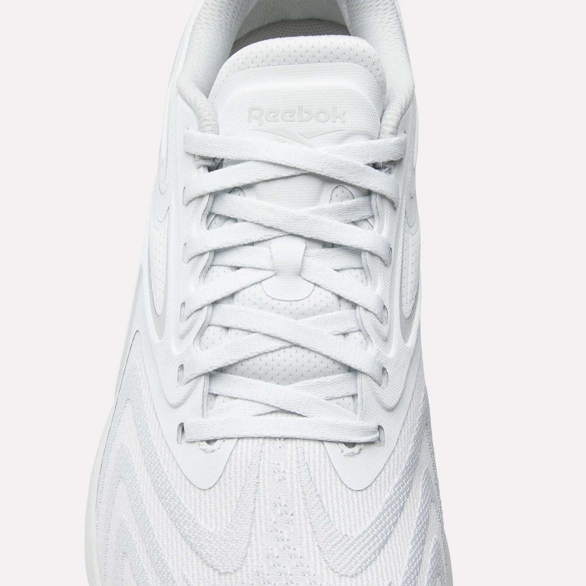 Top view of Reebok Nano X5 Edge Training Shoes in white with white laces, Flexweave textured upper, and embossed Reebok logo on the tongue—precision performance footwear for training.