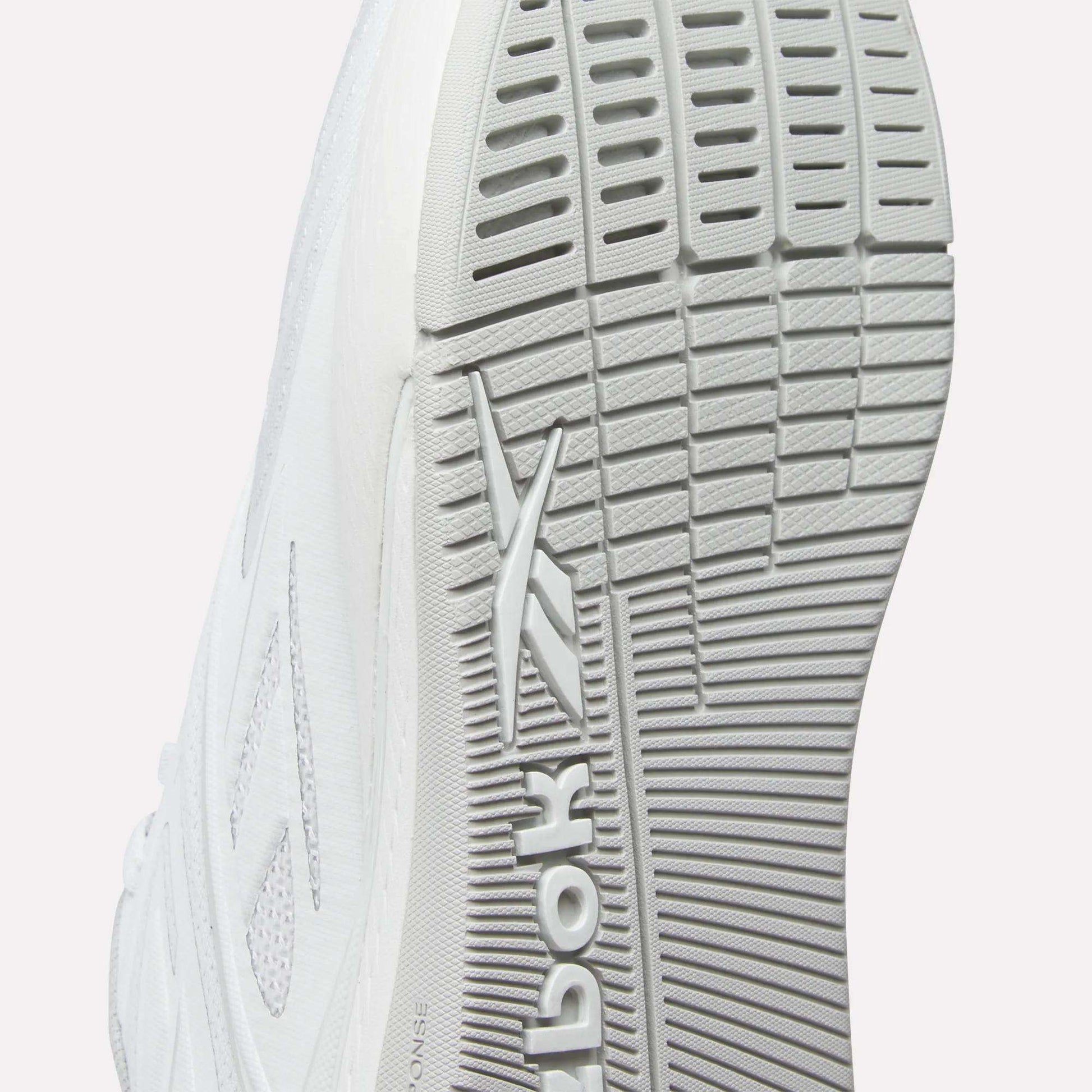 Close-up of the sole on Reebok Nano X5 Edge Training Shoes, featuring a textured tread pattern and Flexweave upper, with the Reebok logo embossed on the bottom.