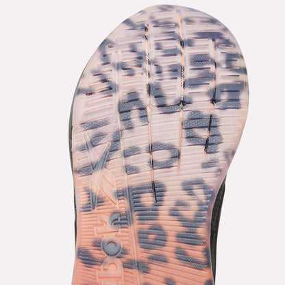 Close-up of the translucent outsole on the Reebok Women's Nano X5 Edge Training Shoes, showing bold black leopard spots over a pink-orange gradient, with grooves and embossed details visible.