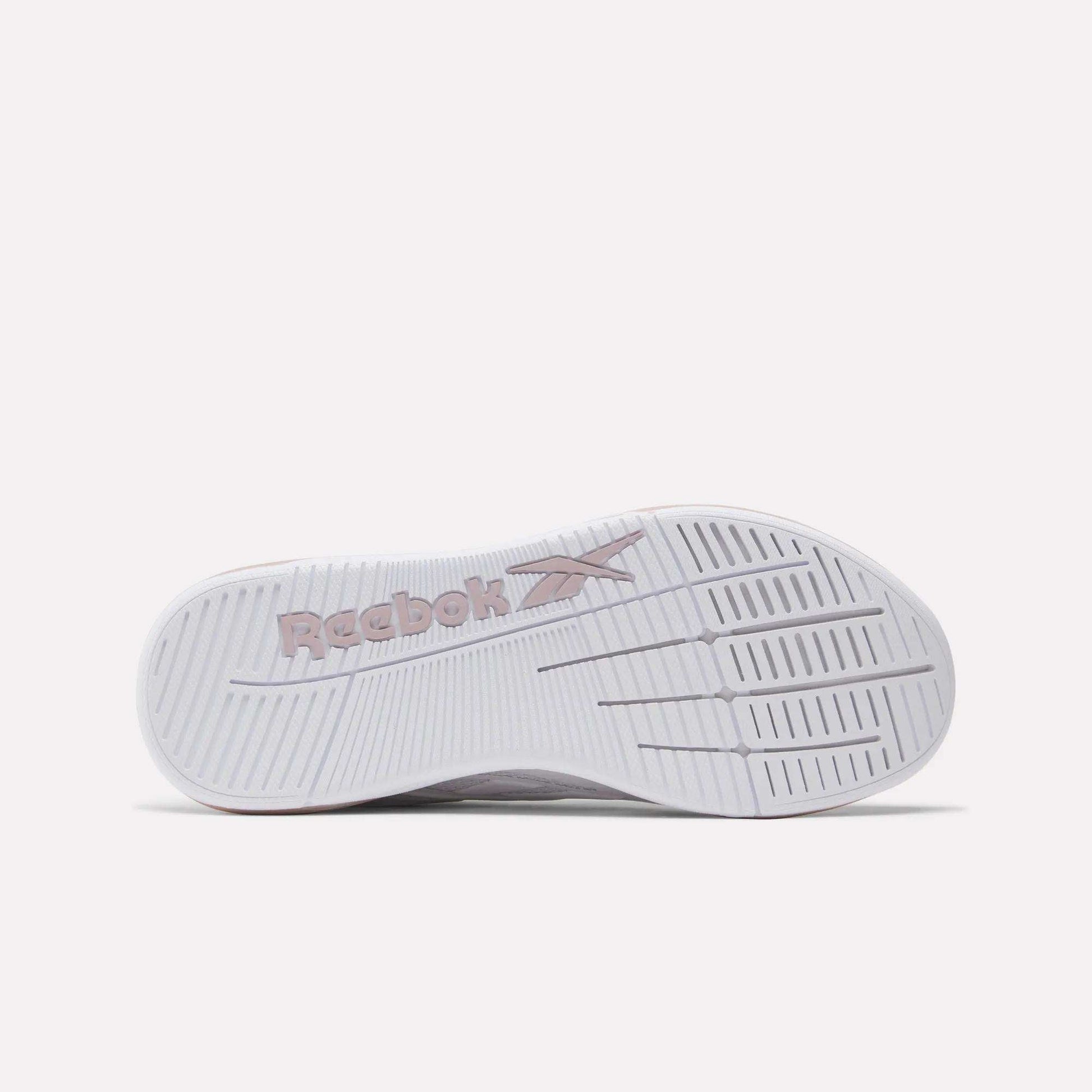 The image displays the sole of a white Women's Nano X5 Edge Training Shoe by Reebok, featuring the embossed Reebok logo in light pink and textured grooves for enhanced grip—perfect for training or HIIT workouts.