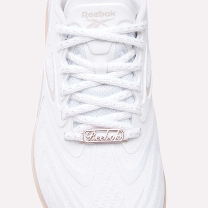 Close-up of the Women's Nano X5 Edge Training Shoes by Reebok, featuring a white textured upper, detailed laces, and a metallic logo tag—ideal for HIIT or daily workouts.