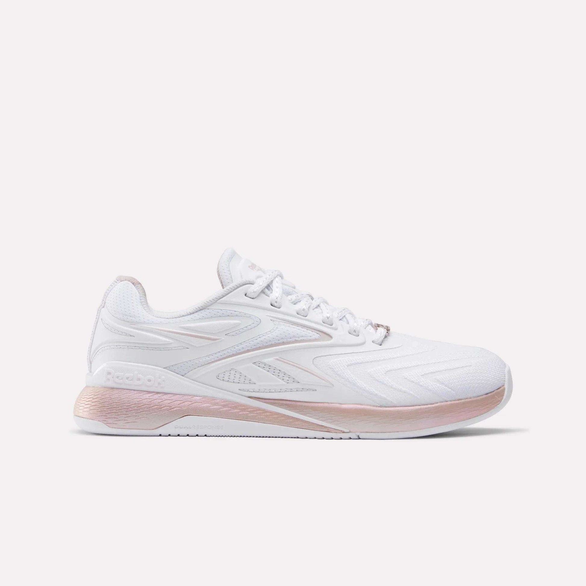 The Reebok Women's Nano X5 Edge Training Shoes feature a white color with pink accents on the sole and heel, a woven texture side design, and the Reebok logo—ideal for versatile workouts.