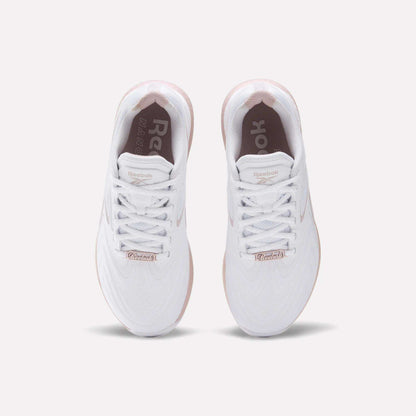 The Reebok Women's Nano X5 Edge Training Shoes feature a white upper, white laces, and a light pink sole. The Reebok logo appears on the insoles and tongue, combining style and performance—ideal for HIIT workouts.