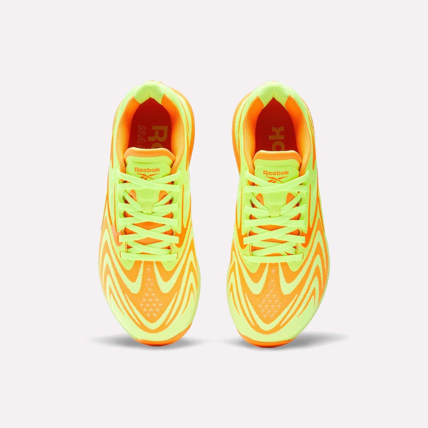 Top view of Reebok Women's Nano X5 Edge Training Shoes in neon yellow and orange with wave patterns and matching laces, ideal for HIIT workouts, shown on a plain white background.
