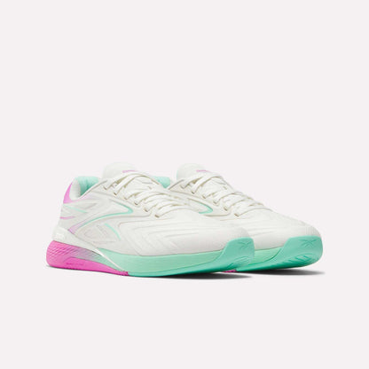 Reebok Women's Nano X5 Edge Training Shoes in white with mint green front soles, pink heel soles, and matching accents—perfect for HIIT—are shown on a white background.