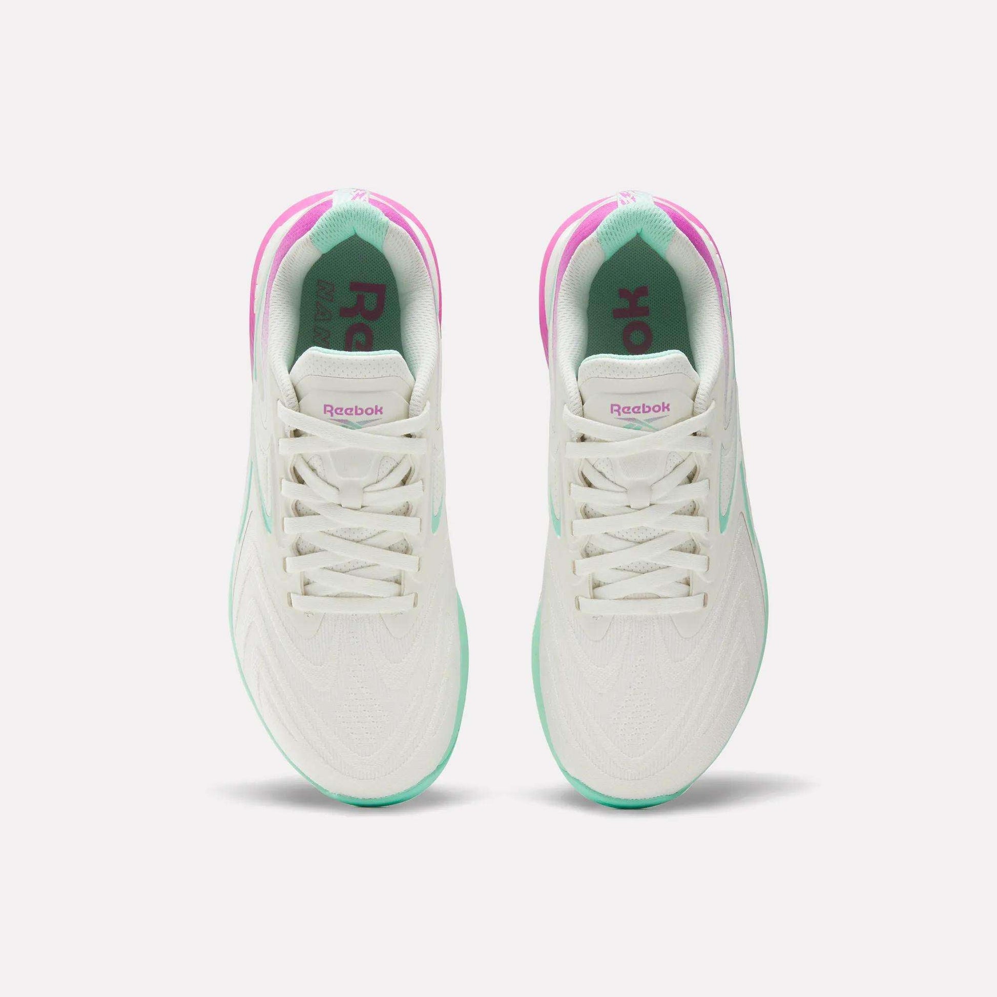 Top view of Women's Nano X5 Edge Training Shoes by Reebok, featuring pink and green accents, white laces, and branded tongues—ideal for HIIT—displayed side by side on a plain white background.