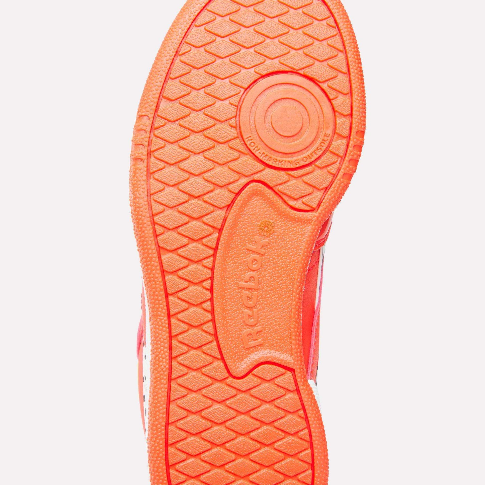 The bright orange sole of the Reebok x Paw Patrol Club C Revenge Shoes for little kids features a textured grip pattern, a circular heel design, retro tennis style vibes, and an embossed Reebok logo at the center.