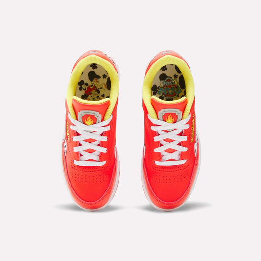 Top view of Reebok x Paw Patrol Club C Revenge Shoes for little kids, featuring a vibrant red color, white laces, yellow lining, cartoon Paw Patrol insoles, retro tennis style, and playful flame detail on the tongue.