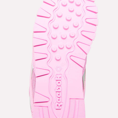 Close-up of the pink sole of Reebok x Paw Patrol Classic Nylon Shoes for little kids, featuring the Reebok brand name and logo in the center, with textured patterns and grooves for added grip.