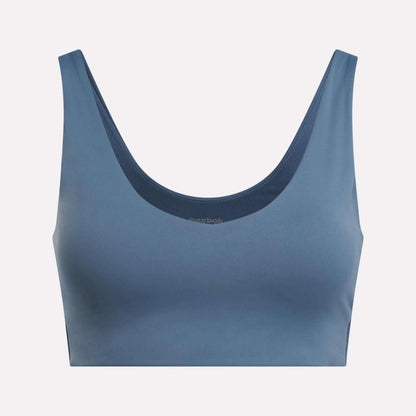 The Reebok Women's Yoga V-Neck Bra in blue features a seamless design and supportive fit, ideal for studio workouts. Shown on a light background.