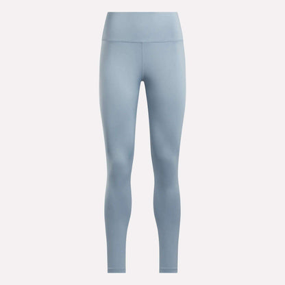 The Reebok Women's Core High-Rise Leggings in light blue feature a seamless, high-waisted, full-length design and are made with RBK-DRY fabric. Shown on a plain white background for a sleek look with no visible patterns or logos.