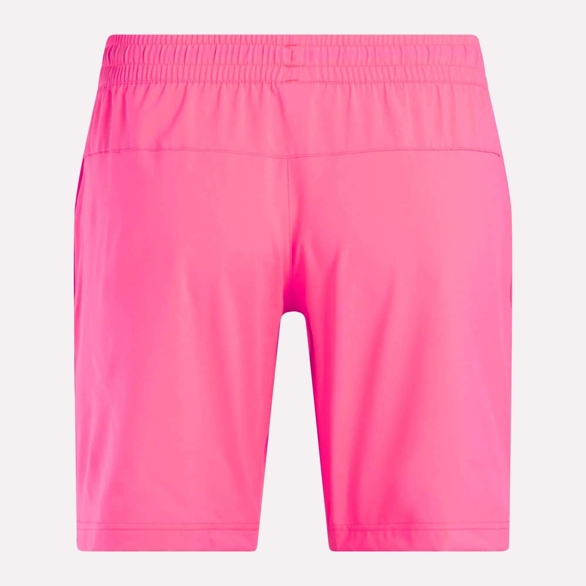Men’s Workout Ready Woven Shorts by Reebok in bright pink, shown from the back. These shorts are knee-length with an elastic waistband and made from smooth, lightweight woven fabric, displayed against a plain white background.