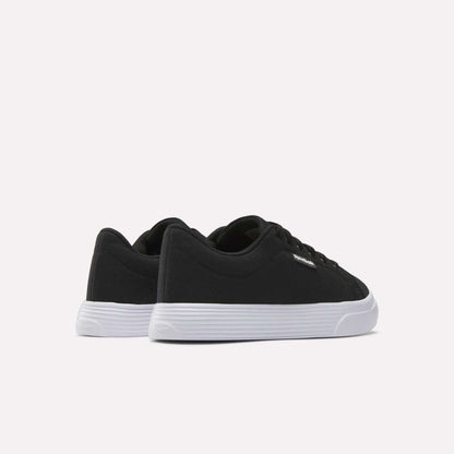 The Women's OnLux Court Lite Walking Shoes by Reebok are black low-top, comfortable walking shoes with white rubber soles, displayed from the back and side on a plain white background.