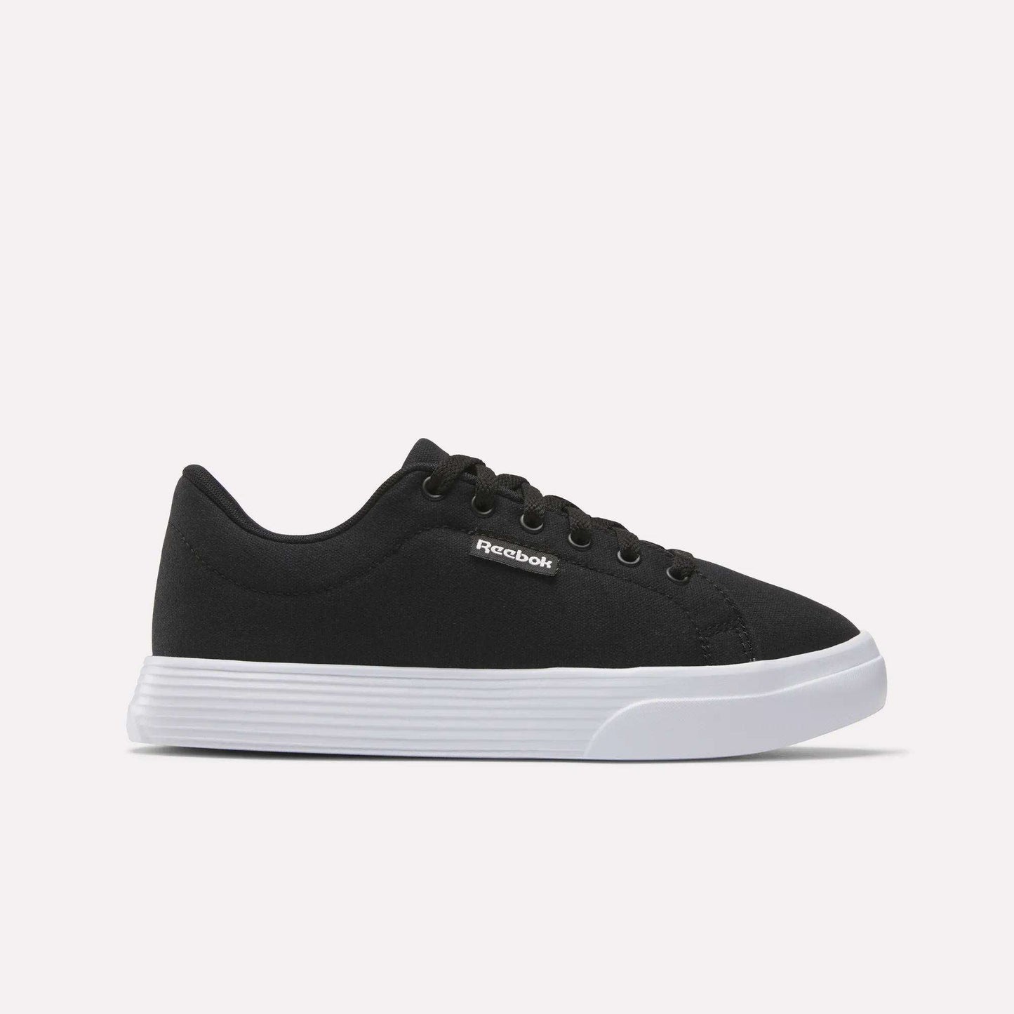 The Reebok Women's OnLux Court Lite Walking Shoes feature a black design with black laces and a white rubber sole, displayed in side profile on a light background—ideal for comfortable all-day walking.