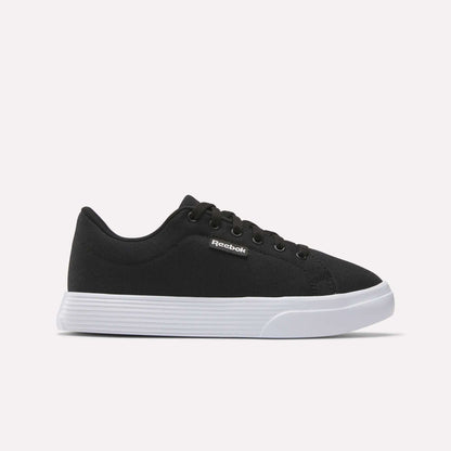The Reebok Women's OnLux Court Lite Walking Shoes feature a black design with black laces and a white rubber sole, displayed in side profile on a light background—ideal for comfortable all-day walking.