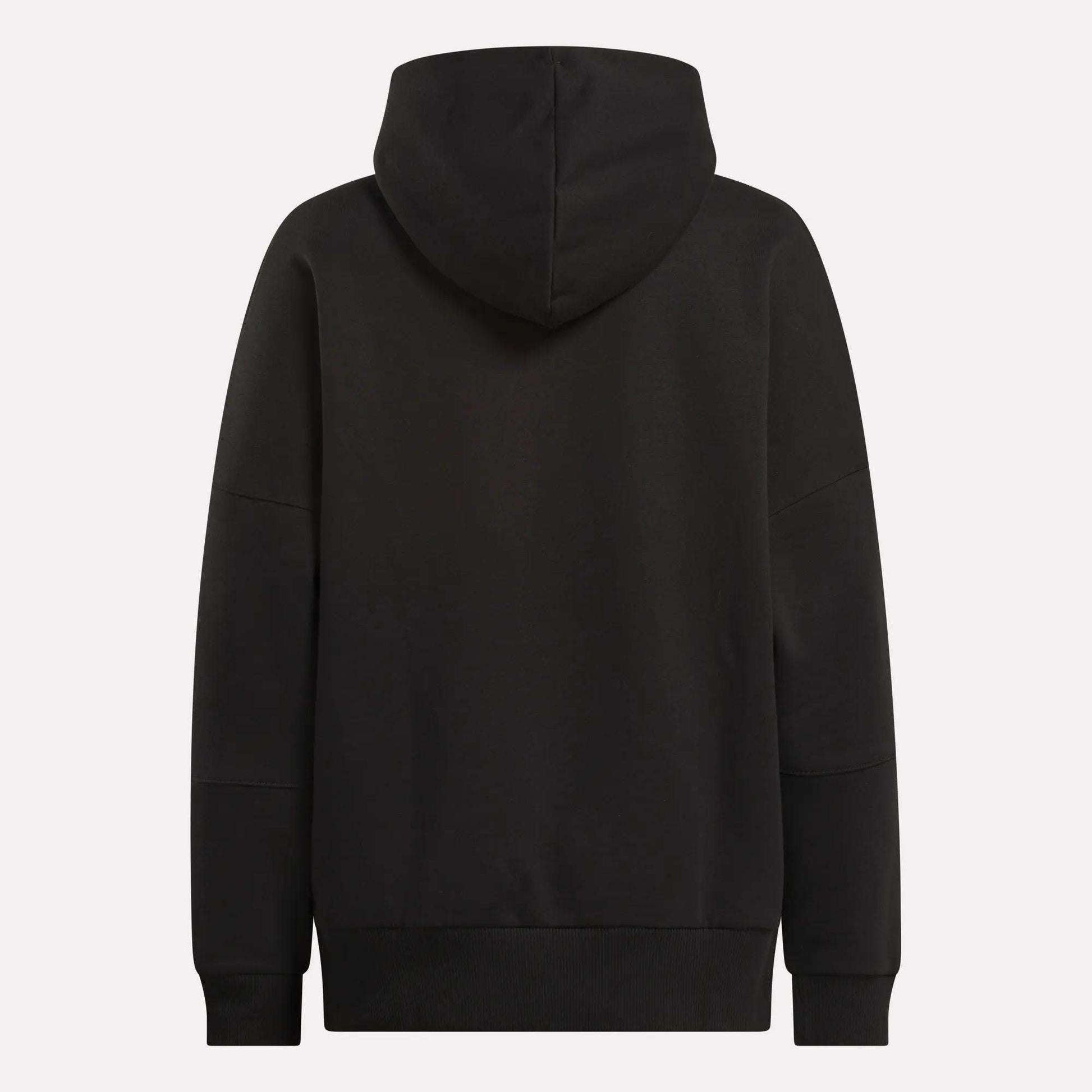 The Reebok Women's Lux Hoodie is shown from the back in plain black, with an oversized fit, long sleeves, and the hood up. It has no visible logos or patterns—ideal for a relaxed, cozy look.