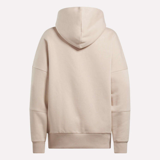 The Reebok Women's Lux Hoodie in beige features an oversized fit, long sleeves, large hood, and ribbed cuffs and waistband, shown from the back against a plain white background.