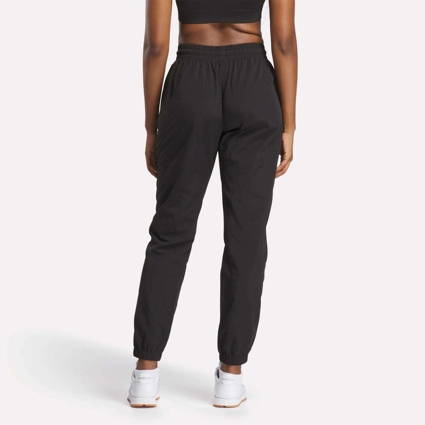 A woman wearing Reebok Women's Vector Track Pants.
