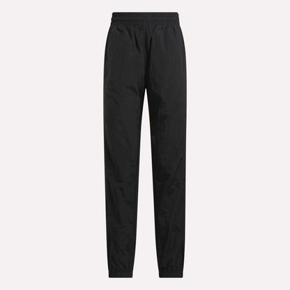 Women's Vector Track Pants by Reebok in black, featuring full length, an elastic waistband, and elastic cuffs, shown against a plain light background.
