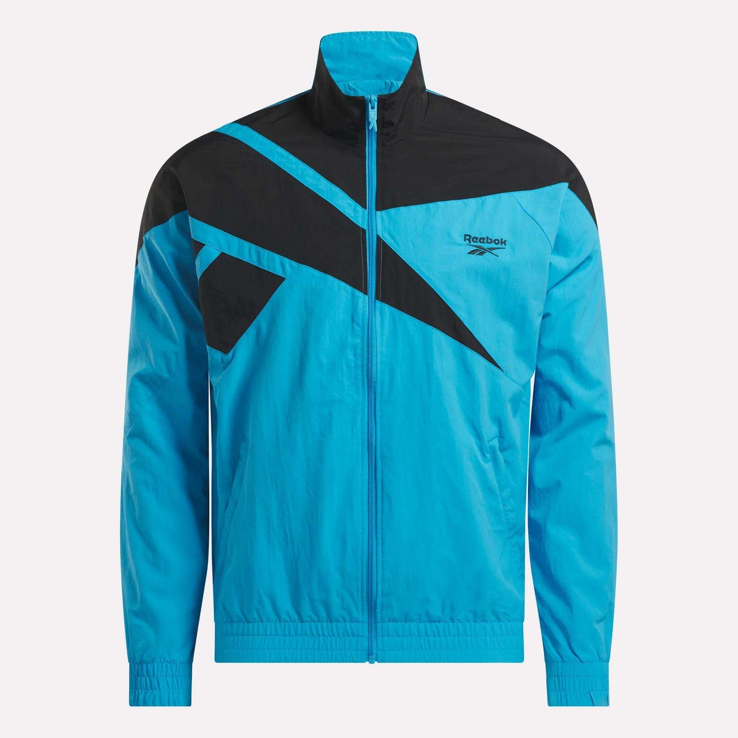 The Reebok Men's Classics Track Top features a blue design with black geometric accents on the chest and shoulders, zip-up front, high collar, elastic cuffs, and a Reebok logo on the left chest for casual comfort.