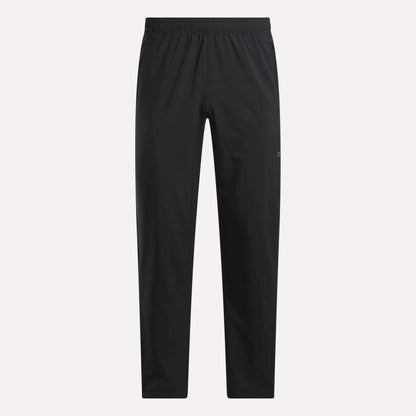 The Reebok Men's Train Woven Unlined Pants feature a black design with an elastic waistband and straight legs. Lightweight and pocketless, they're ideal for gym or daily wear, shown here on a plain white background.