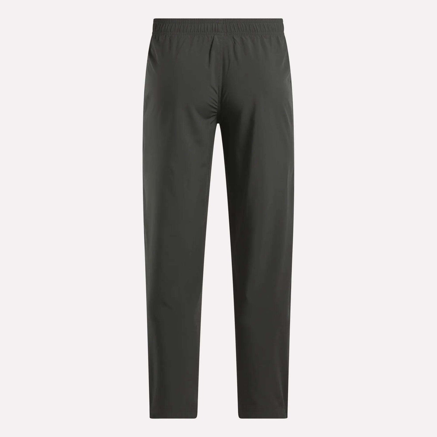 Reebok Men's Train Woven Unlined Pants in dark gray feature a straight-leg design and elastic waistband, ideal as lightweight workout or gym pants. Shown against a light background.