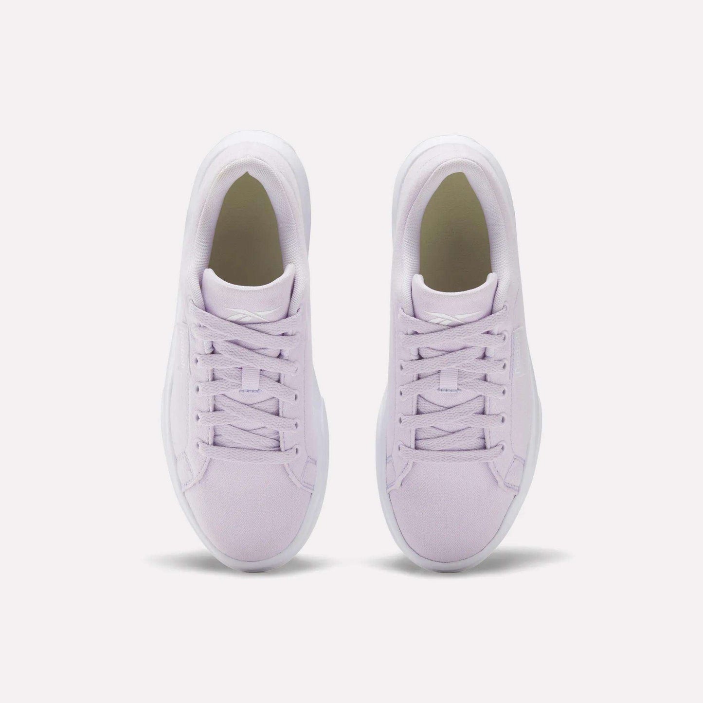 A pair of Reebok Women's OnLux Court Lite Walking Shoes in light purple, shown from above side by side on a white background, feature matching laces and white soles for lightweight, comfortable walks.