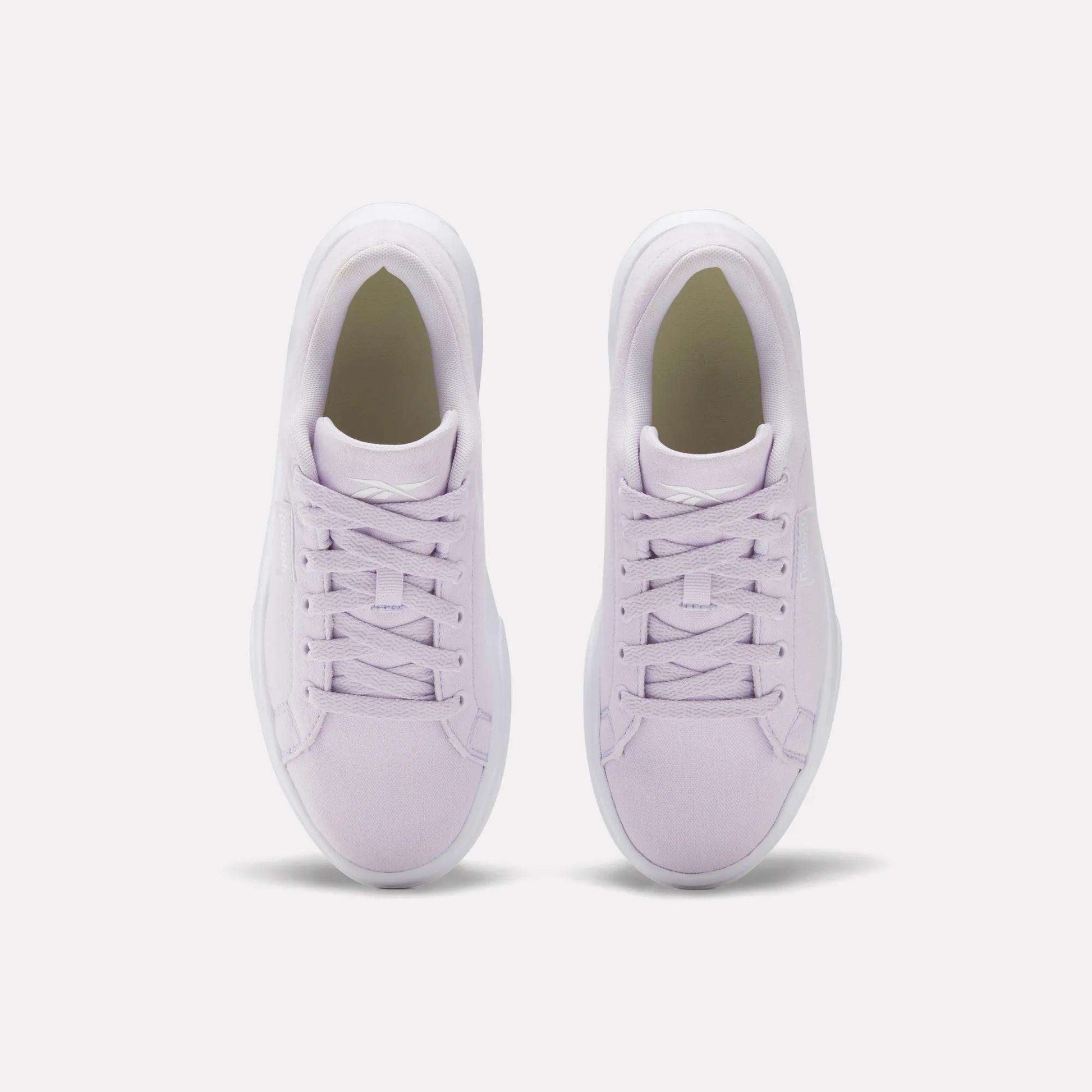 A pair of Reebok Women's OnLux Court Lite Walking Shoes in light purple, shown from above side by side on a white background, feature matching laces and white soles for lightweight, comfortable walks.