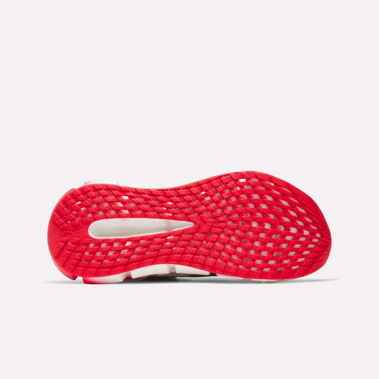 The image shows the bottom of a Reebok Women's FloatZig 2 AHA Running Shoe, featuring a bright red, grid-patterned sole with energy-returning cushioning in the cutout section. The background is plain white.