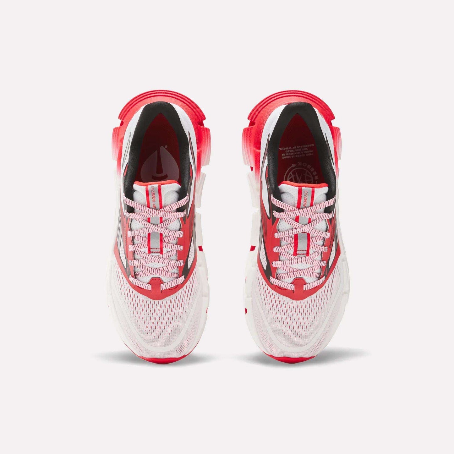 The Men's FloatZig 2 AHA Running Shoes by Reebok are shown from above, featuring white mesh uppers, energy-returning cushioning, red accents on the heel and toe, and white laces with red stripes against a light background.