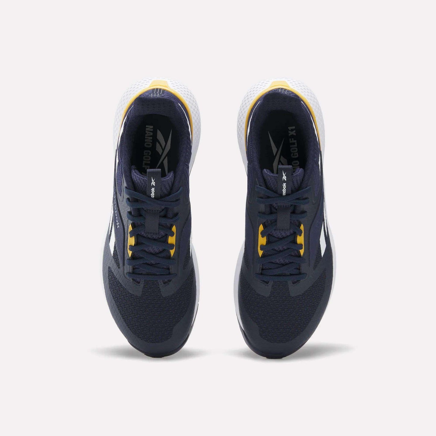 Top view of a pair of Reebok Nano Golf Shoes in dark navy with yellow accents, featuring a lightweight FlexWeave upper, white heel detail, and white outsole, placed side by side on a light background.