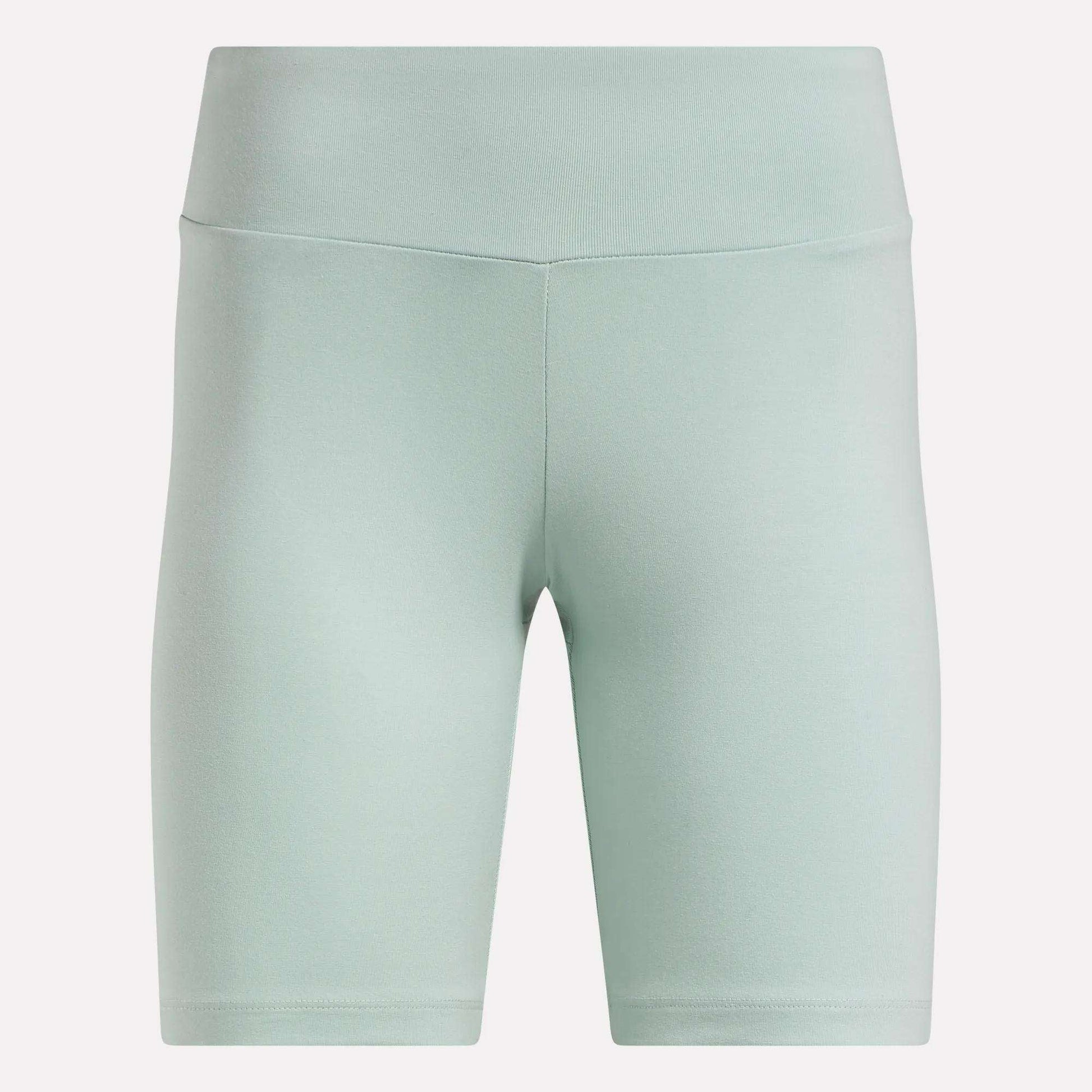 Reebok Women's Small Logo Cycle Shorts in light green feature a high-waist, smooth cotton finish, front seam detailing, and fitted knee-length stretchy design, shown against a plain white background.