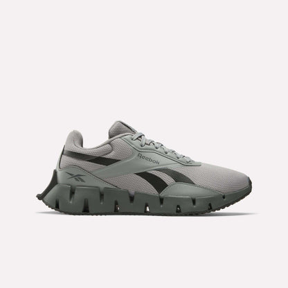 The Reebok Zig Dynamica STR Shoes feature a gray and black mesh upper, EVA cushioning for comfort, a distinctive segmented sole, black side logo, and lace-up closure, shown on a plain white background.
