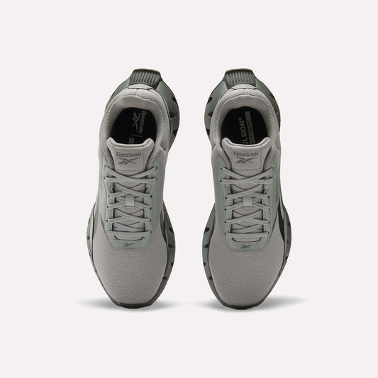 A pair of light gray Reebok Zig Dynamica STR Shoes viewed from above, featuring a mesh upper, lace-up fronts, black outsoles, plush EVA cushioning, and the Reebok logo on the tongue and insole.
