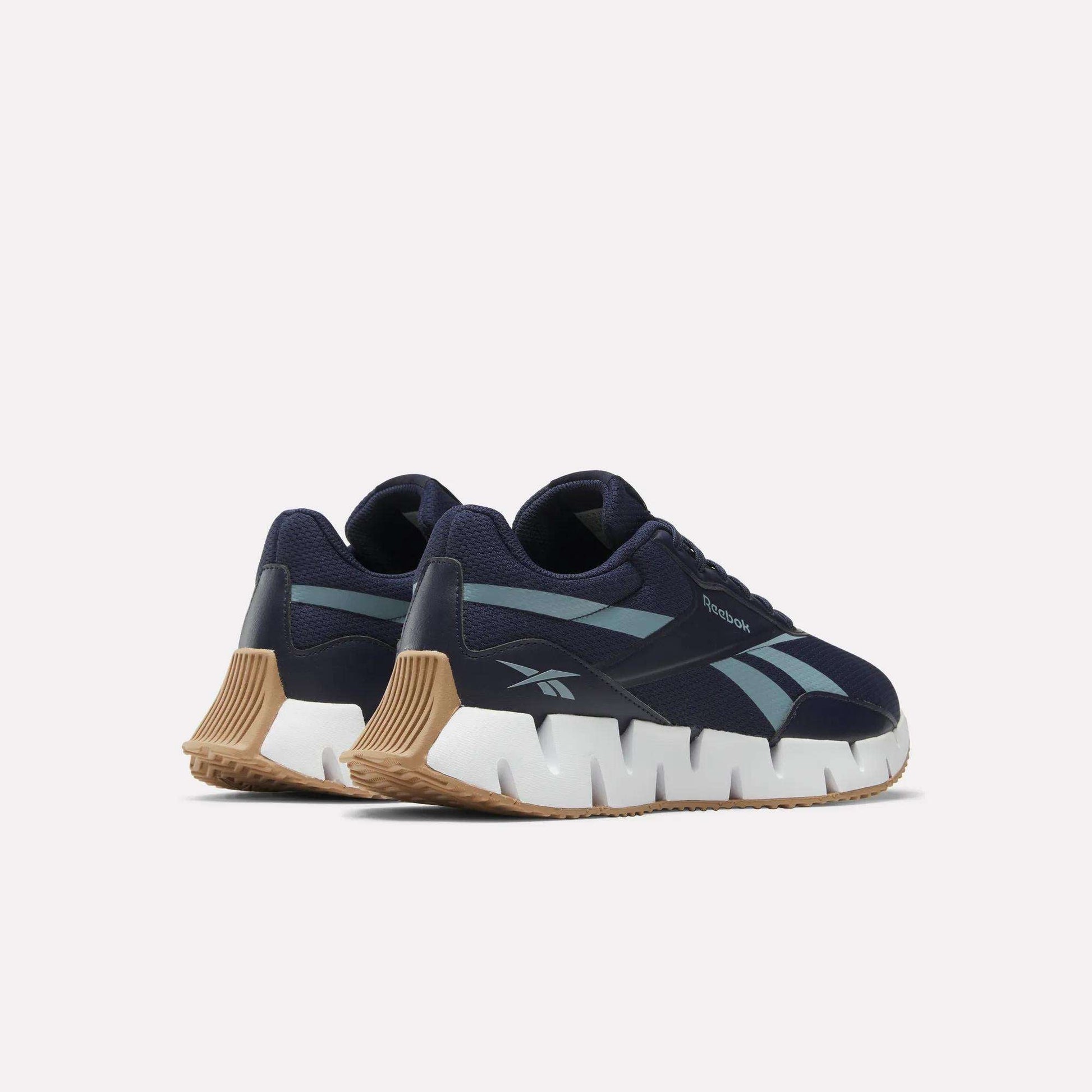 The Reebok Zig Dynamica STR Shoes feature a navy mesh upper, light blue side stripes, chunky white zigzag soles, and tan rubber outsoles, shown against a plain white background.