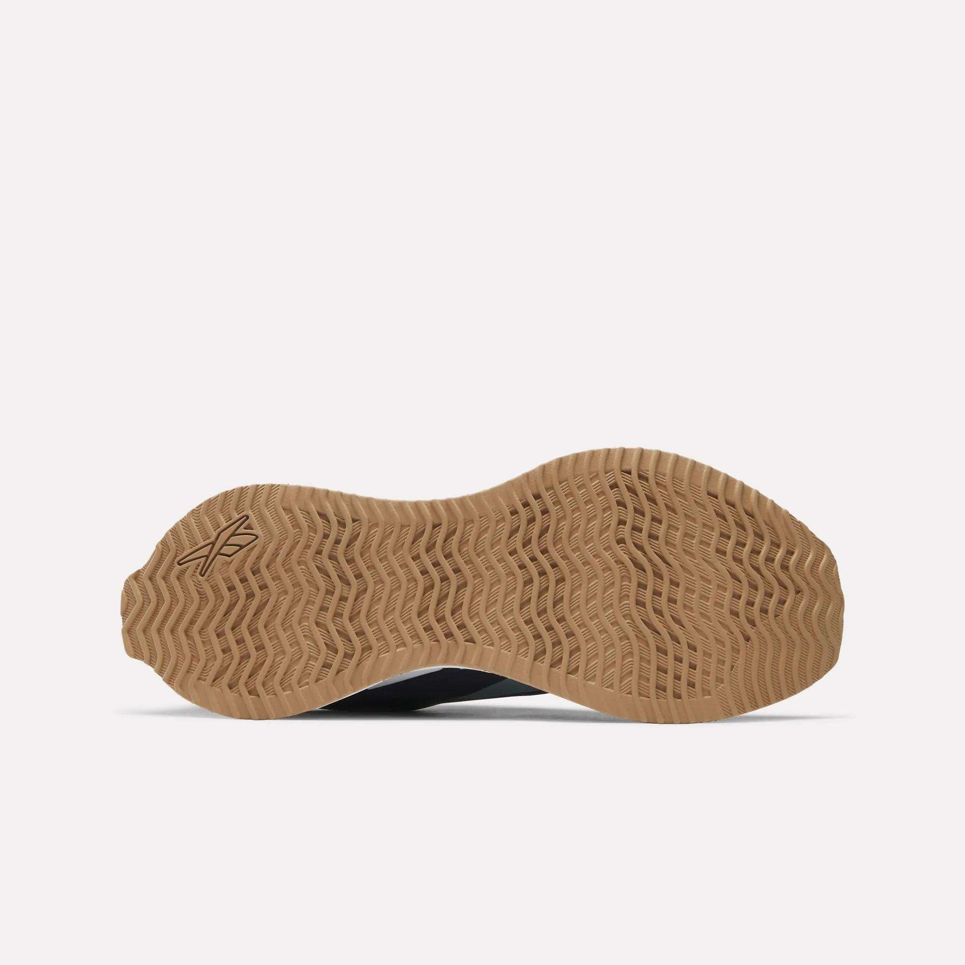 The image displays the bottom view of Reebok Zig Dynamica STR Shoes, featuring a light brown, textured rubber outsole with a wavy zigzag tread pattern and a small logo near the heel. The background is plain white.