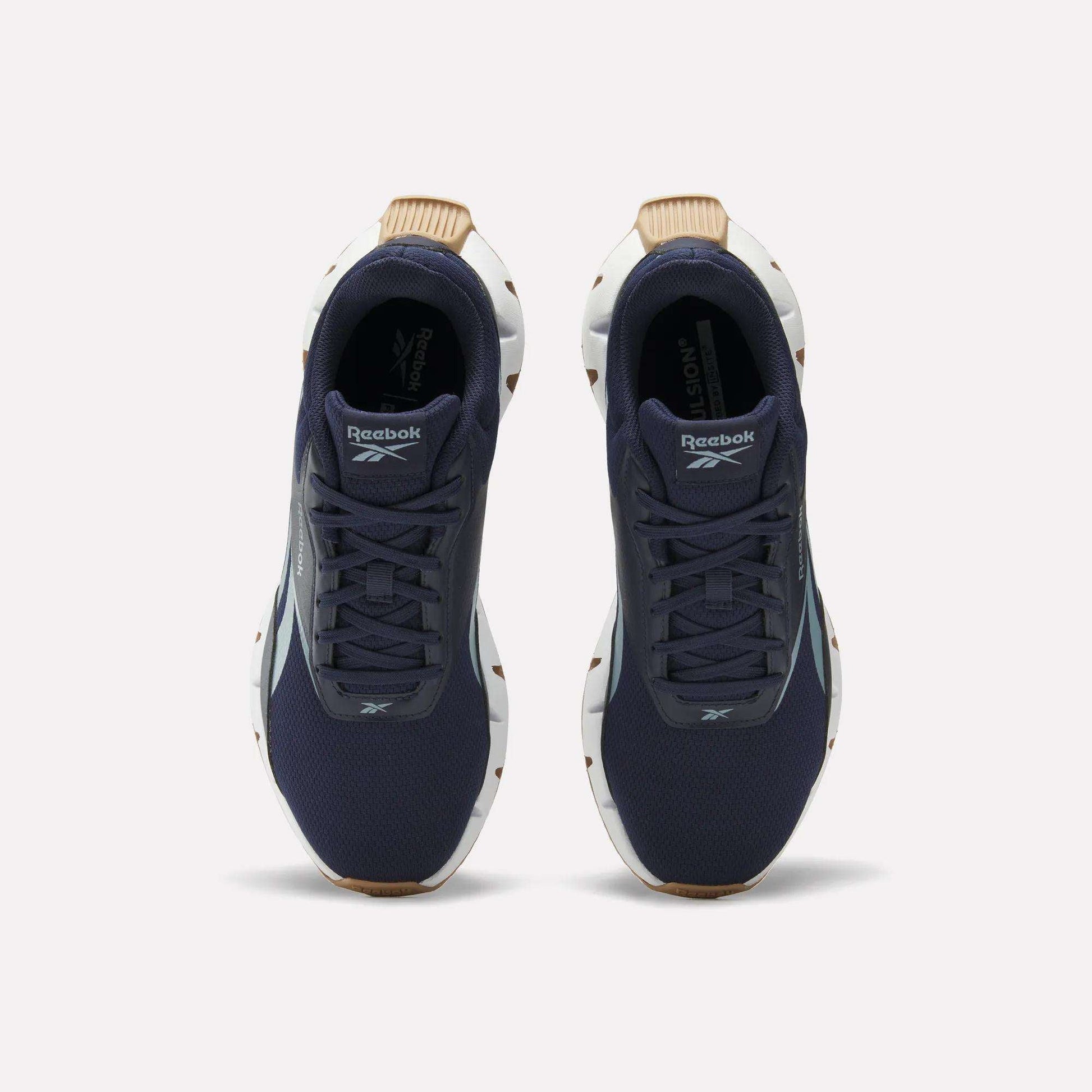 A pair of Reebok Zig Dynamica STR Shoes in dark blue with a breathable mesh upper, white soles, and brown accents, viewed from above on a plain white background.