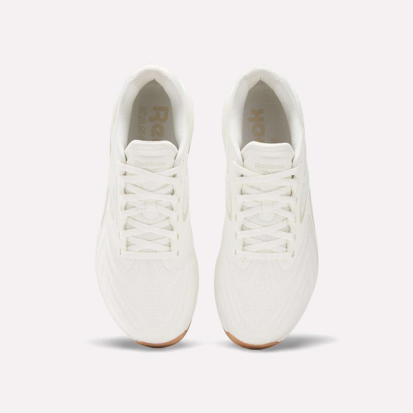 Top view of Reebok Nano X5 Edge Training Shoes in all-white with white laces and gum soles, placed side by side on a plain light background, designed for peak performance.