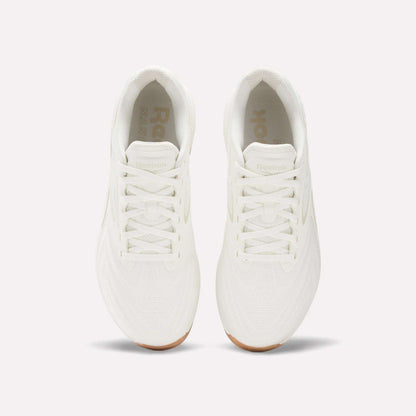 Top view of Reebok Nano X5 Edge Training Shoes in all-white with white laces and gum soles, placed side by side on a plain light background, designed for peak performance.