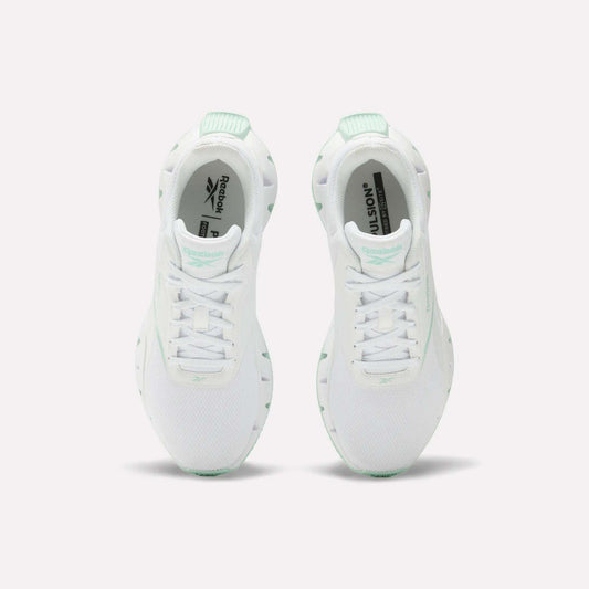 A pair of Reebok Women's Zig Dynamica STR Shoes in white with mint green accents, featuring breathable mesh for comfort, shown from above on a plain white background.