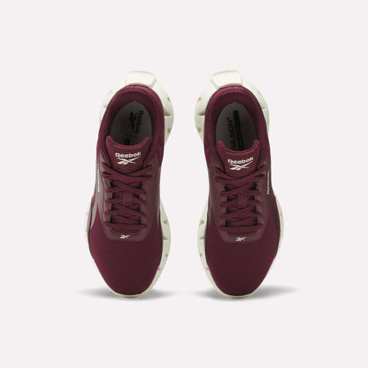 A pair of maroon Reebok Women's Zig Dynamica STR Shoes with white soles, seen from above on a white background. The breathable mesh upper and Reebok logos are visible on the tongue and side of each shoe.
