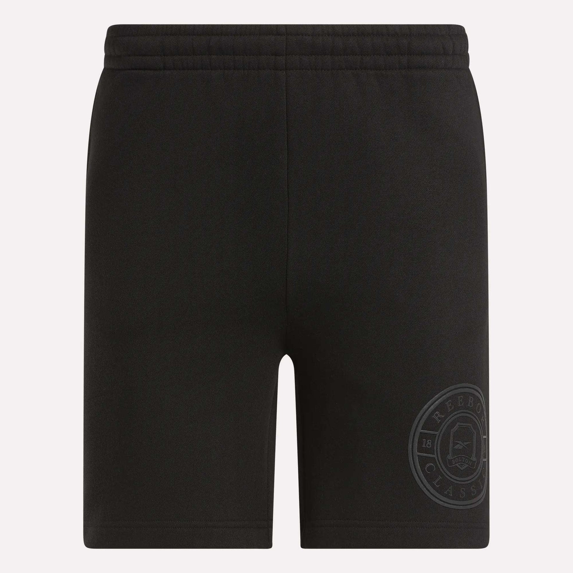 Men's Crest Shorts by Reebok: black relaxed fit cotton shorts for men with an elastic waistband and a subtle Classic logo near the hem. These shorts are plain, with no visible pockets or drawstrings.