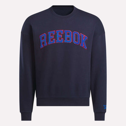 The Reebok Men's Crew Sweatshirt in navy features bold REEBOK lettering in red and blue outline across the chest, shown on a plain background.